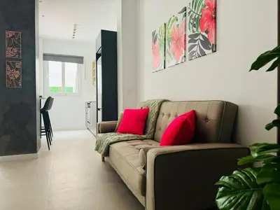 a living room with a couch with two pink pillows at PLANAS 3 Designer Aparment with Terraza in Ruzafa SOHO in Valencia