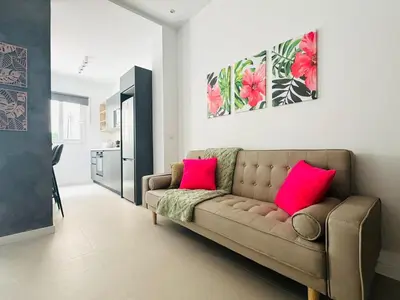 a living room with a couch and two pink pillows at PLANAS 3 Designer Aparment with Terraza in Ruzafa SOHO in Valencia