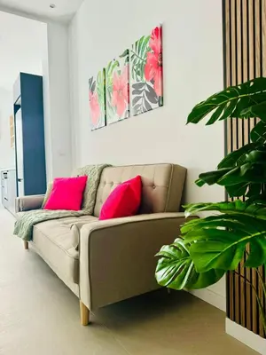 a living room with a couch with two pink pillows at PLANAS 3 Designer Aparment with Terraza in Ruzafa SOHO in Valencia