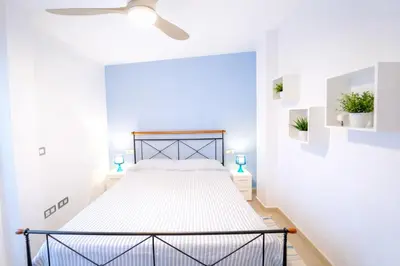 a bedroom with a bed in a white room at Dúplex tranquilo frente al mar en Xilxes Terraza, parking y WiFi in Chilches