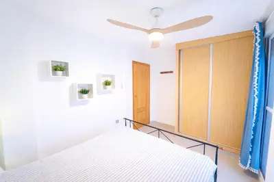 a bedroom with a bed and a wooden door at Dúplex tranquilo frente al mar en Xilxes Terraza, parking y WiFi in Chilches