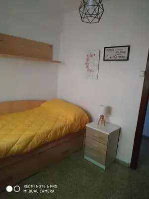 a bedroom with a yellow bed and a night stand at EL Cid II in Valencia