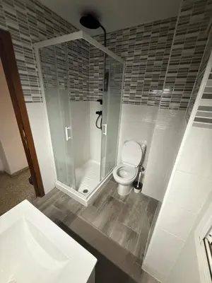 a bathroom with a toilet and a glass shower at EL Cid II in Valencia