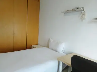 a small bedroom with a white bed and a desk at luxury and relax in Valencia