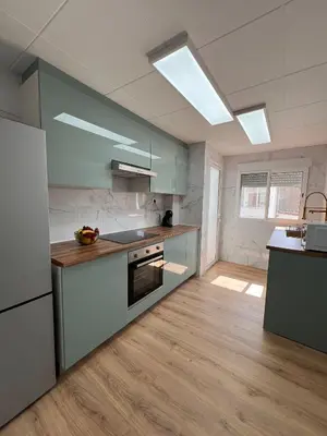 a kitchen with green cabinets and a stove top oven at El Surtidor in Anna