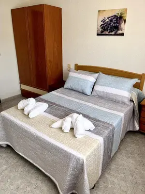 two beds in a hotel room with towels on them at Casa el Catorce 18 in Bolbaite