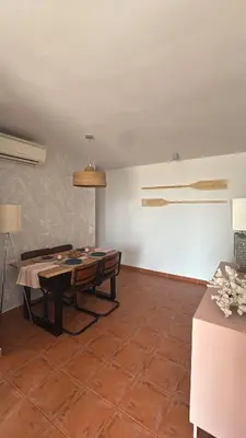 a dining room with a table and a white wall at Gaviota Azul, Perelló in Sueca