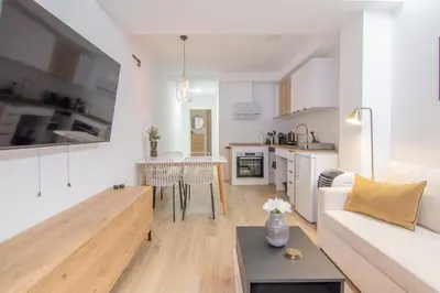 a living room and kitchen with a couch and a table at Casa Sant Domènec Savio in Valencia