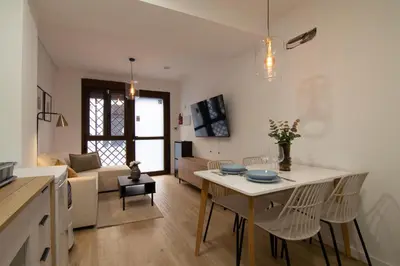 a kitchen and living room with a table and chairs at Casa Sant Domènec Savio in Valencia