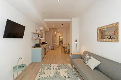 a living room with a gray couch and a kitchen at GuestReady - Charming place in Valencia in Valencia