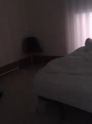 a dark room with a bed and a chair at Apartamento Cerca las Playa in Valencia