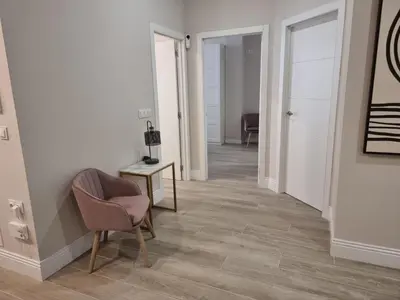 a hallway with a chair and a table with a lamp at MD Senda del Aire in Valencia