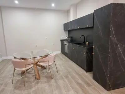 a kitchen with a glass table and two pink chairs at MD Senda del Aire in Valencia