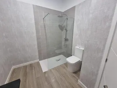 a bathroom with a toilet and a glass shower at MD Senda del Aire in Valencia