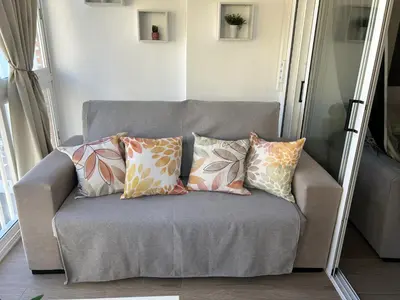 a couch with pillows on it in a living room at Apartamento Bahía Cullera II in Cullera