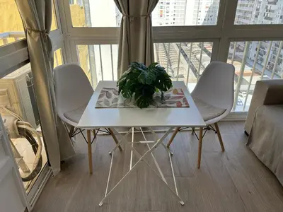 a white table and chairs in a room with a window at Apartamento Bahía Cullera II in Cullera