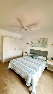 a bedroom with a bed and a ceiling fan at Apartamento Bahía Cullera II in Cullera