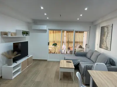 a living room with a couch and a tv at Apartamento Bahía Cullera II in Cullera