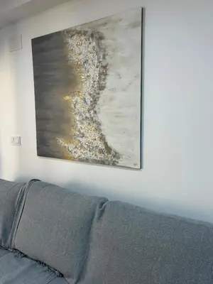 a painting hanging on a wall above a couch at Apartamento Bahía Cullera II in Cullera