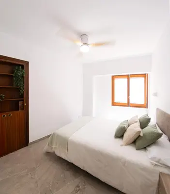 a white bedroom with a bed and a ceiling fan at Aromes d'Espadà in Eslida