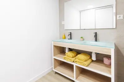 a bathroom with a sink and yellow towels at Urban apartment BAJO 6 - HOUSEVANLIVE in Valencia
