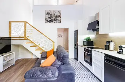 a living room with a couch and a staircase at Urban apartment BAJO 6 - HOUSEVANLIVE in Valencia