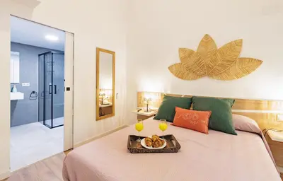 a bedroom with a tray of food and two glasses of wine at Urban apartment BAJO 8 - HOUSEVANLIVE in Valencia
