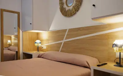 a bedroom with a bed and a mirror and two lamps at Urban apartment BAJO 8 - HOUSEVANLIVE in Valencia