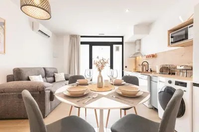 a kitchen and living room with a table and chairs at Suite Deluxe Valencia - Beach Apartments I in Valencia
