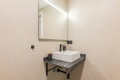 a bathroom with a white sink and a mirror at Suite Deluxe Valencia - Beach Apartments I in Valencia