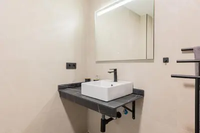 a bathroom with a white sink and a mirror at Suite Deluxe Valencia - Beach II Apartments in Valencia