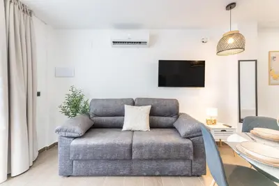 a living room with a couch and a tv at Suite Deluxe Valencia - Beach II Apartments in Valencia