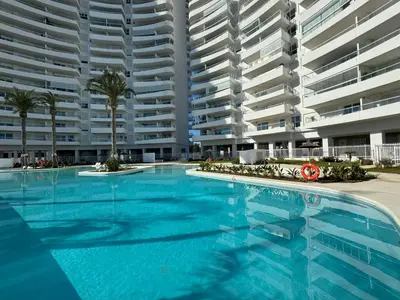 a large swimming pool with two large apartment buildings at Gran Canet Salva, moderno apartamento con terraza y vistas al mar in Canet de Berenguer