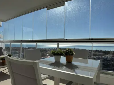 a dining room with a table and a large window at Gran Canet Salva, moderno apartamento con terraza y vistas al mar in Canet de Berenguer