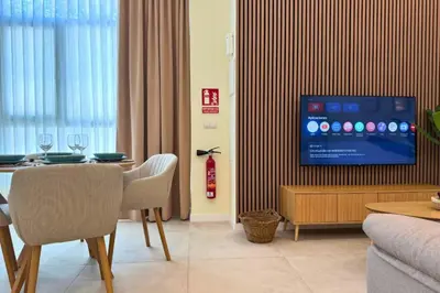 a living room with a table and a tv at Illetes Flats - Suite cerca de Feria de Muestras y Metro in Valencia