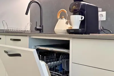 a kitchen counter with a dishwasher with a tea kettle and dishes at Illetes Flats - Suite cerca de Feria de Muestras y Metro in Valencia