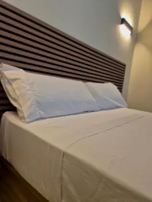 a bed with white sheets and pillows in a bedroom at Illetes Flats - Suite cerca de Feria de Muestras y Metro in Valencia