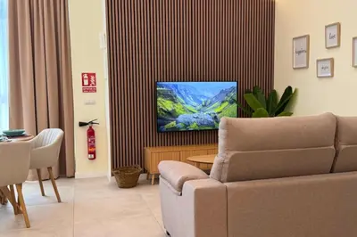 a living room with a couch and a tv at Illetes Flats - Suite cerca de Feria de Muestras y Metro in Valencia