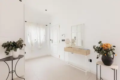 a white room with flowers on a table and a mirror at Spacious villa with private pool & garden for 4 in Partida de La Cañada