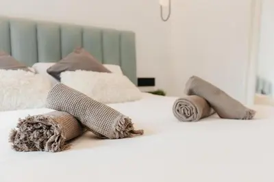 a white bed with pillows on top of it at Spacious villa with private pool & garden for 4 in Partida de La Cañada