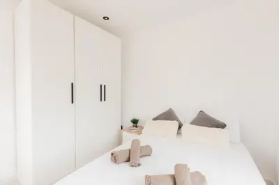a white bedroom with a bed with white cabinets at Spacious villa with private pool & garden for 4 in Partida de La Cañada