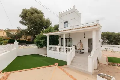 a white house with a lawn in front of it at Spacious villa with private pool & garden for 4 in Partida de La Cañada