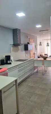 a kitchen with white cabinets and tables in a room at Apartment Nules in Nules
