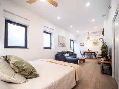 a bedroom with a bed and a living room at Bonito loft para 4 personas in Valencia