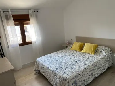 a bedroom with a bed with two yellow pillows at Casa EL CRUCE Navarrés in Navarrés