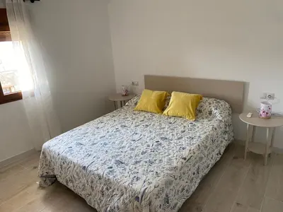 a bedroom with a bed with two yellow pillows at Casa EL CRUCE Navarrés in Navarrés