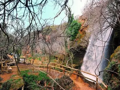 a waterfall in the middle of a forest with trees at Casa EL CRUCE Navarrés in Navarrés