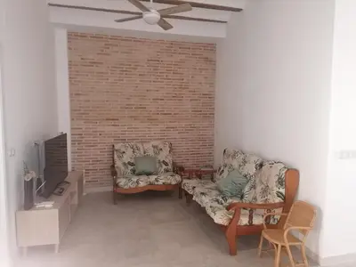 a living room with two couches and a brick wall at Casa EL CRUCE Navarrés in Navarrés