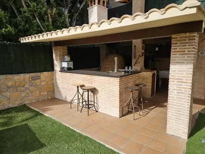 an outdoor bar with stools in a brick patio at Amazing Villa with swimming pool in Torrent