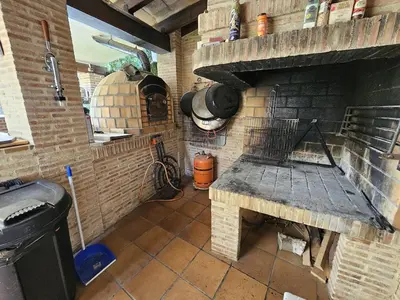 a kitchen with a brick fireplace and a stove at Amazing Villa with swimming pool in Torrent